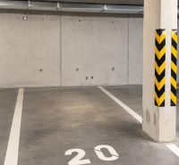Podzemní garáž s betonovou podlahou a označením parkovacího místa číslo 20.