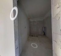 Interiér rodinného domu s omítnutými stěnami a vestavěnými otvory pro instalace.