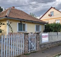 Rodinný dům v Tornyosnémeti s cihlovou střechou a barevným plotem.