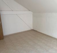 Prázdná místnost s dlažbou a dřevěnými dveřmi v kanceláři.