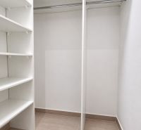 Šatník s policemi a šatníkovou tyčí v 2-pokojovém bytě.