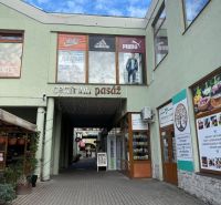 Obchodní prostory v Topoľčanech se vstupem do centra pasáže a pohledem na vitríny.