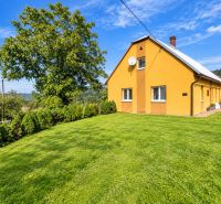 Rodinný dům na ulici Košariská v Oščadnici obklopený velkou zahradou a stromy.