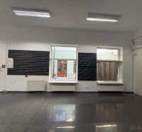 Obchodní prostory s šedou podlahou a velkým oknem.