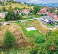 Pozemky - bydlení v Detvě s výhledem na okolní domy a přírodní scenérii.