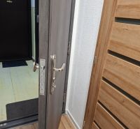 Vstupní dveře s kováním v 1-pokojovém bytě, podlaha s dřevěným dekorem.