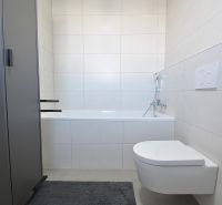 Koupelna s vanou a závěsným WC ve 3-pokojovém bytě. Minimalistický design.