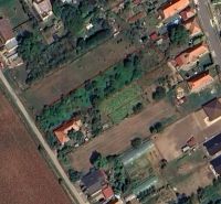 Pozemky na bydlení v Jasové s vyznačeným územím, obklopené zelení a budovami.