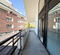 Balkon 3-pokojového bytu v Donovalech na ulici Donovaly, s výhledem na sousední budovy.