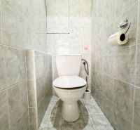 Toaleta s obkladem a toaletním papírem v 3-pokojovém bytě.