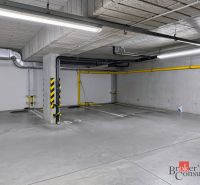 Parkovací místo v podzemní garáži na barevně označené podlaze.