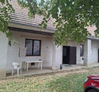 Před domem na Hlavní ulici ve Viničném, Pozemky - bydlení, stojí stoly.