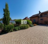 Rodinný dům na Bratislavské ulici v Malinově obklopený udržovanou zahradou a dlažbou.