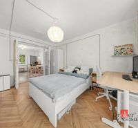 Ložnice s podlahou s dřevěným dekorem a pracovním stolem v 2pokojovém bytě.