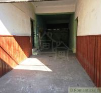 Garáž v obchodních prostorách Modrého Kamene se stěnami s dřevěným obkladem.