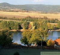 Jezero obklopené podzimními stromy a kopci v zahradách v Krupině.