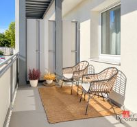 Balkon na ulici Alexandra Matušky v Banské Bystrici s ratanovými křesly a kobercem.