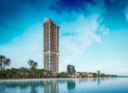 Výstavba bytů v Pattayi u pobřeží s palmami a výraznou výškou budovy.