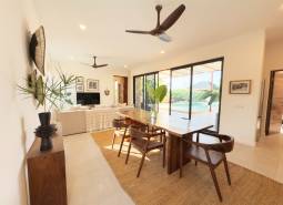 Interiér s jídelním stolem, podlahou s dřevěným dekorem a velkými skleněnými dveřmi, výstavba domů.