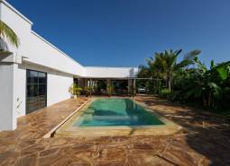 Bílá architektura s bazénem uprostřed zeleně v Paje, Unguja South Region.