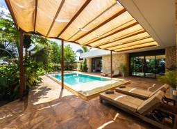 Zahrada rodinného domu na ulici Paje v regionu Unguja South s bazénem a lehátky.