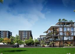 Výstavba bytů v Pattayi obklopená zelení, moderní budovy a auta na pozadí.