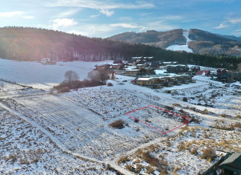 Zimní krajina v Rekreačních pozemcích ve Valči, na ulici Snowland, s horským pozadím.