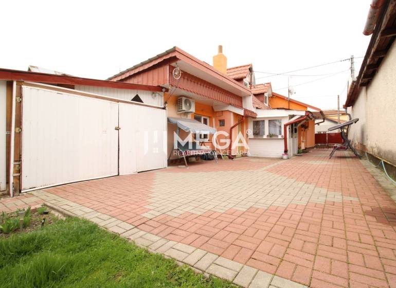 Rodinný dům na ulici Štefana Fidlíka se zpevněným dvorem a garážovými vraty.