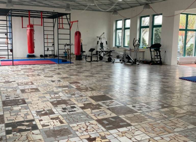 Prostorné kanceláře s boxovacími pytli a fitness vybavením, dlažba z různých druhů mramoru.