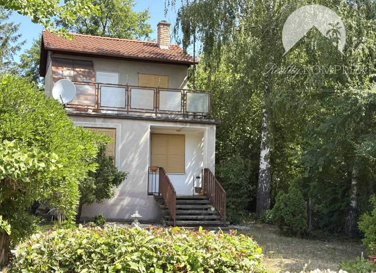 Chata v Radvaňi nad Dunajom, obklopená zelení s terasou a satelitem.