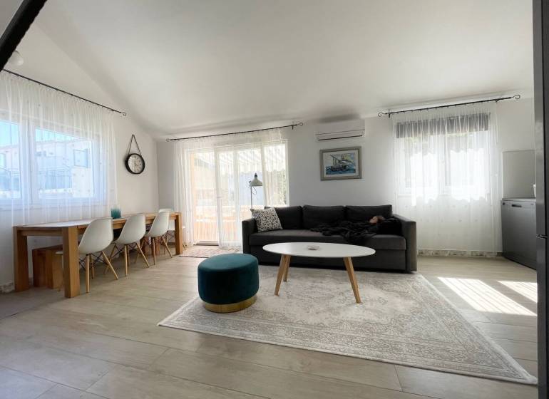 Prostorný obývací prostor rekreačního apartmánu s pohodlným posezením a jídelním stolem.
