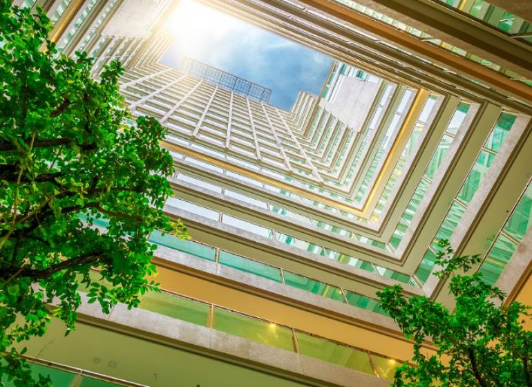 Pohled z atria na výstavbu bytů, s logem 1BCR Real Estate Group.