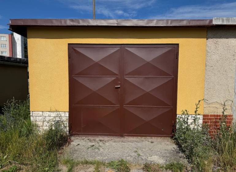Hnědá garáž na Zahradní ulici ve Svitu s rostlinami okolo.