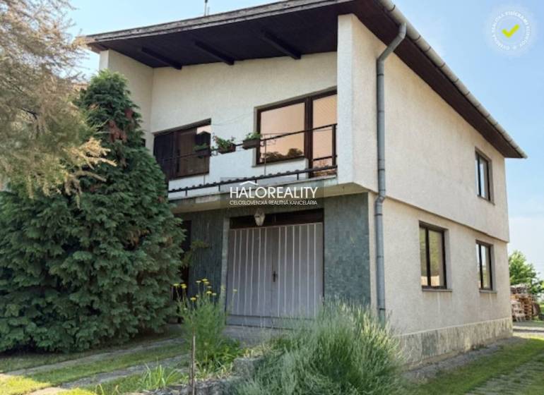 Rodinný dům v Borši s dvěma podlažími, zahradou a jehličnatými stromy.
