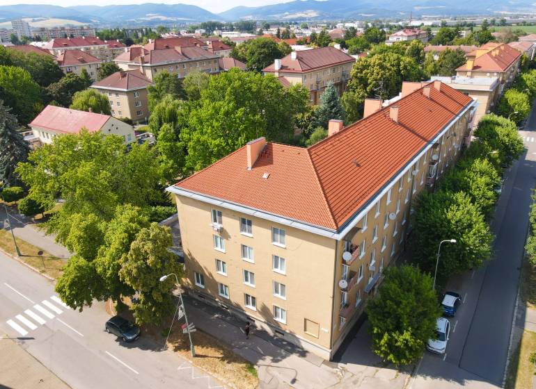 Letecký pohled na 2-pokojový byt v Nové Dubnici obklopený zelení.