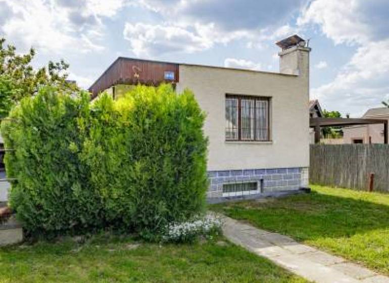 Rodinný dům na ulici Mokráň záhon v Bratislavě-Ružinově, obklopený zelení a trávníkem.