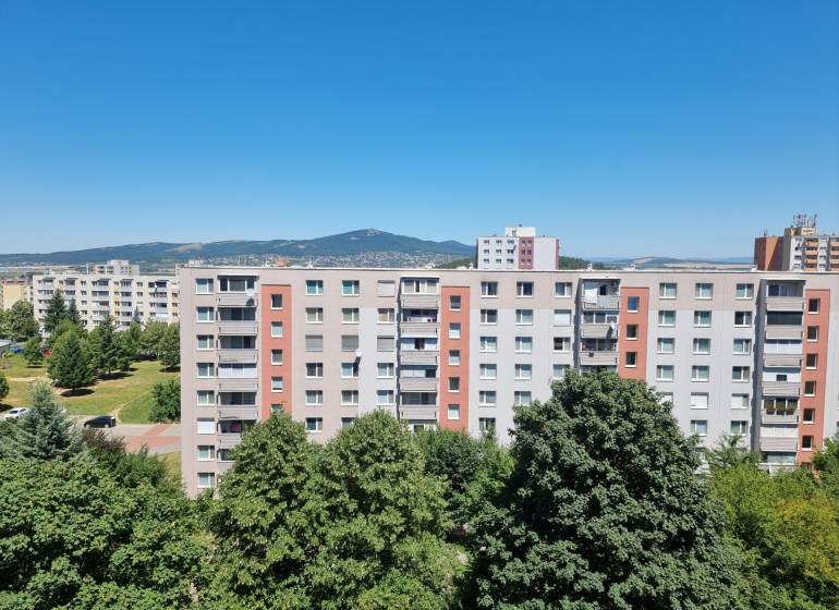 Pohled na bytové domy v Nitře na Petzwalově ulici, s výhledem na okolní přírodu.