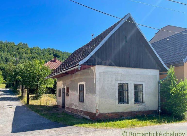 Rodinný dům v Banské Bystrici s tradiční sedlovou střechou, okolní příroda.