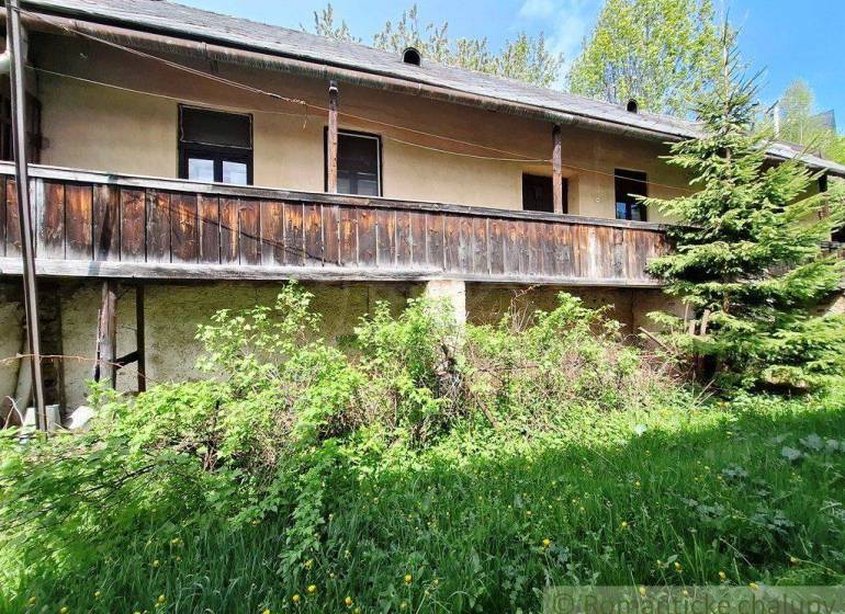 Rodinný dům v Pohorelé se starším dřevěným balkónem a upravenou zelení.