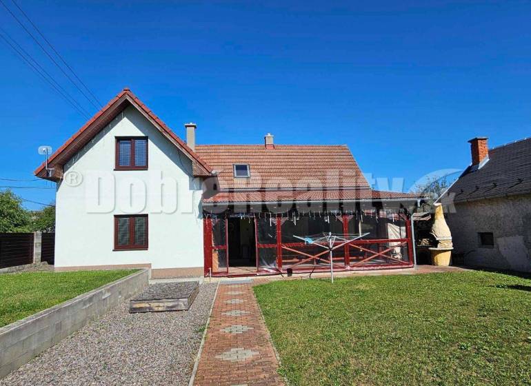 Rodinný dům v Malé Lehotě se sedlovou střechou a upravenou zahradou.