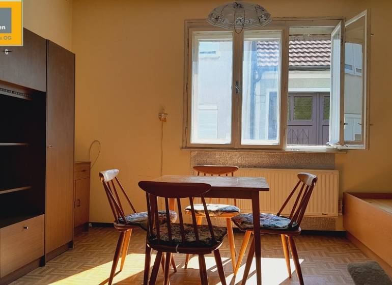 Pokoj se stolem a židlemi osvětlený sluncem, Výstavba bytů.
