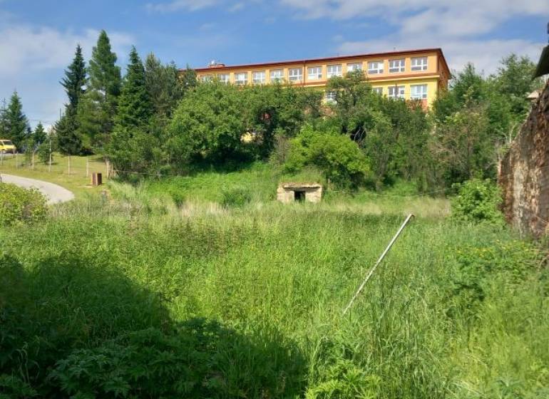 Zeleň a budova v pozadí v Pozemky - bydlení, Ľubotín. Klidné prostředí pro bydlení.
