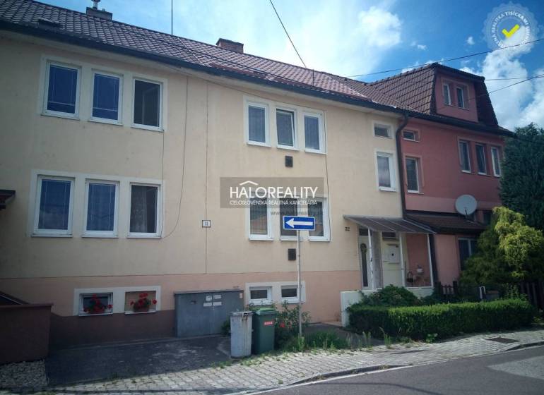 Rodinný dům v Novácích s garáží a květinovou výzdobou na fasádě.
