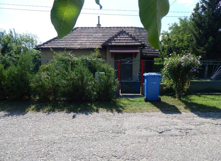Exteriér chaty v Klížskej Nemej, obklopený zelení a brankou.