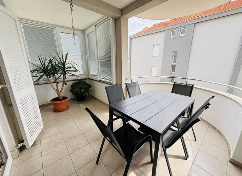 Balkon 3-pokojového bytu v Novalji, s květinami a zahradním nábytkem na dlažbě.