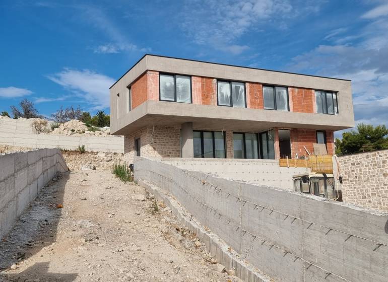 Rozestavěná vila ve Vodicích s betonovou terasou a moderními okny.