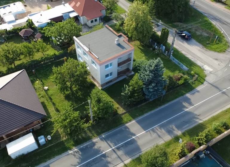 Rodinný dům v Rakoľubech v Novém Městě nad Váhem obklopený zelení a ulicí.