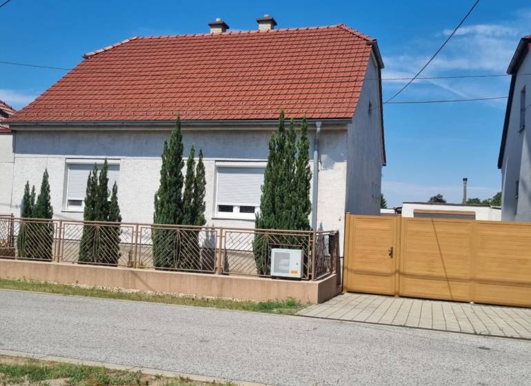 Rodinný dům na ulici Písniky v Malackách, bílá fasáda, červená střecha, túje u plotu.