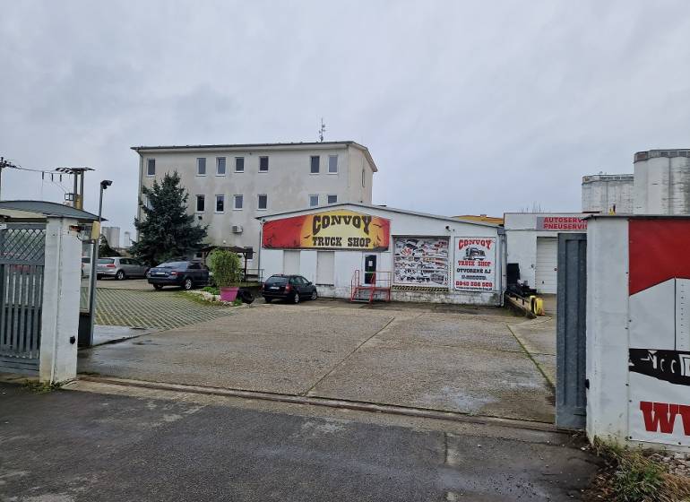 Budova Convoy Truck Shop na ulici Šamorínska, obklopená zaparkovanými auty u skladu a hal.