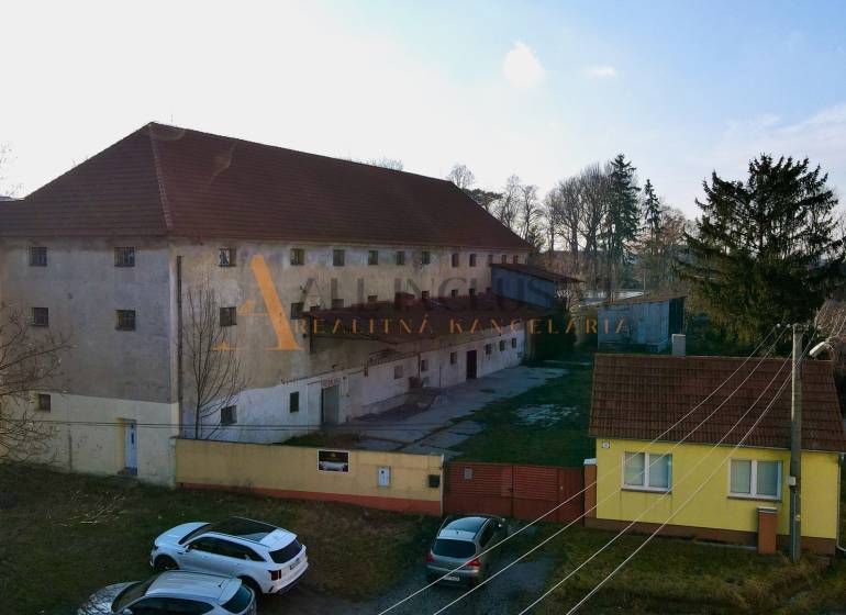 Výrobní prostory v Kovarciach na Hlavní ulici, s prostorným nádvořím a zelení.